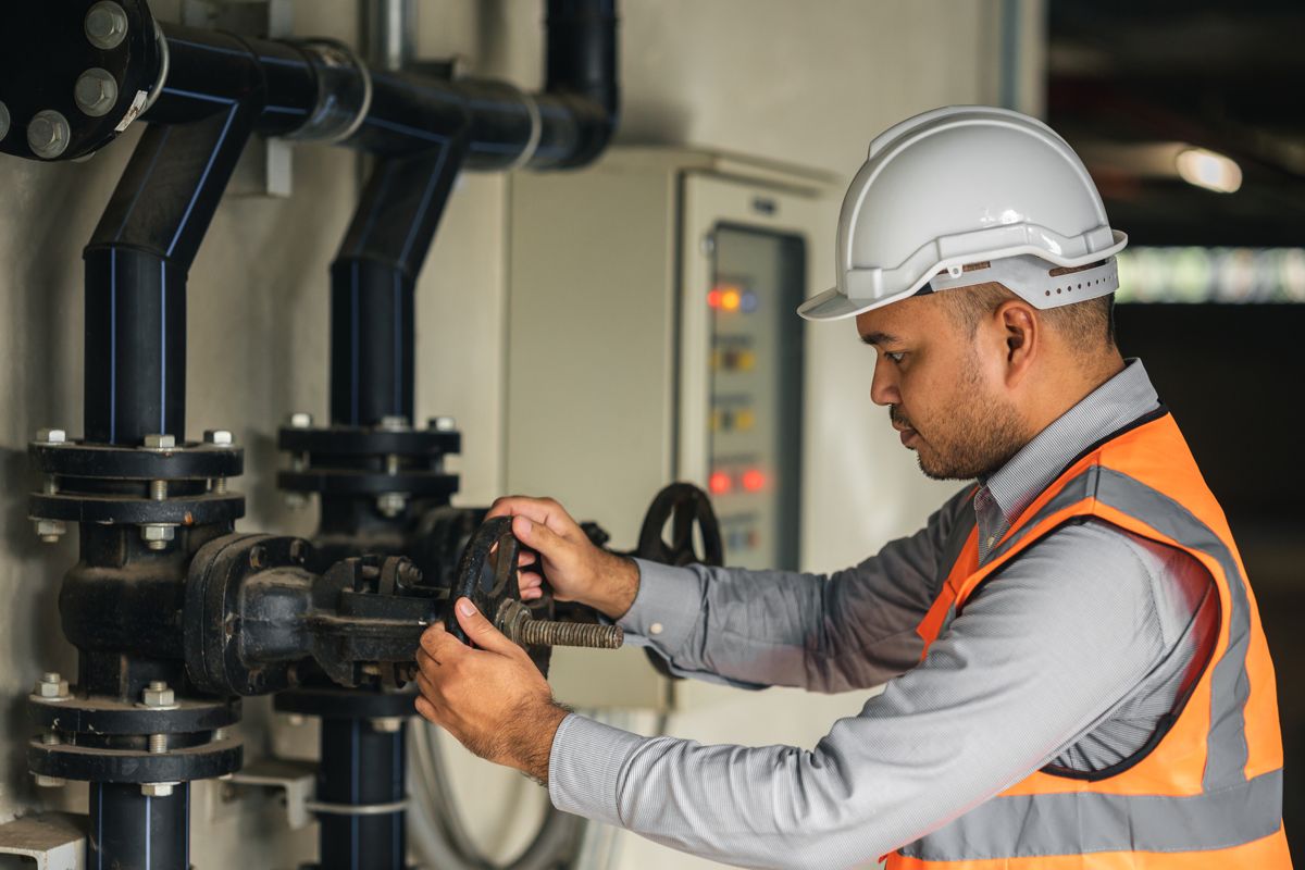 Engineer adjusting a valve in a pumping station