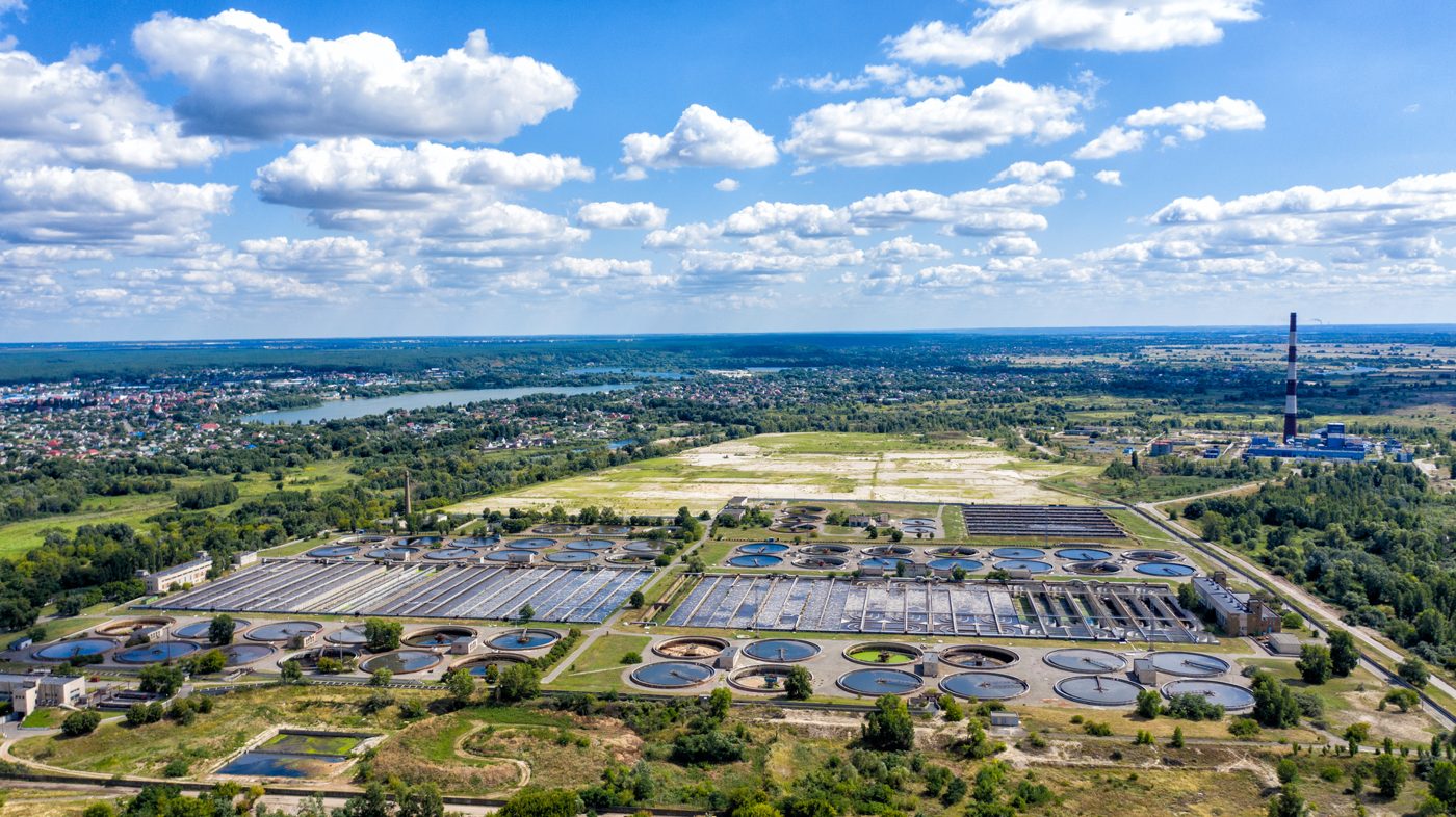 Aerial view of a wastewater treatment plant with clarifiers and aeration basins